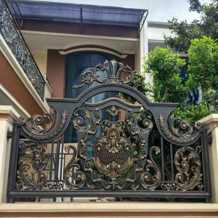 Pagar Tempa Klasik Warna Hitam Emas di Slawi Pagar tempa klasik Slawi dengan desain megah untuk rumah mewah.