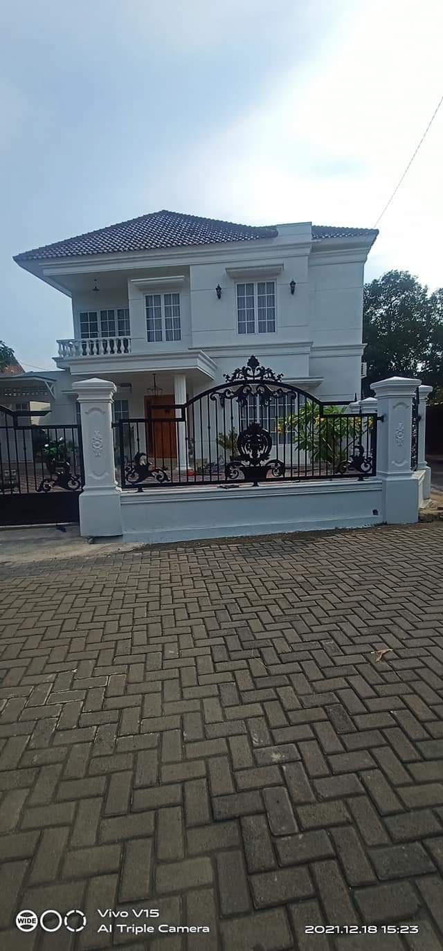 Pagar besi tempa Slawi mewah dengan ornamen klasik yang detail.